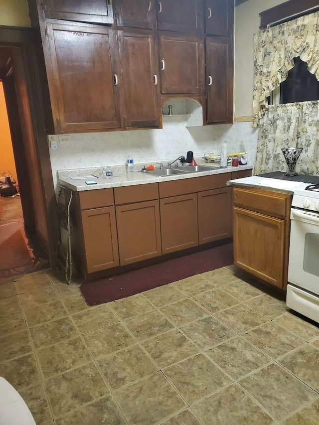 kitchen featuring backsplash, sink, and white range with electric stovetop