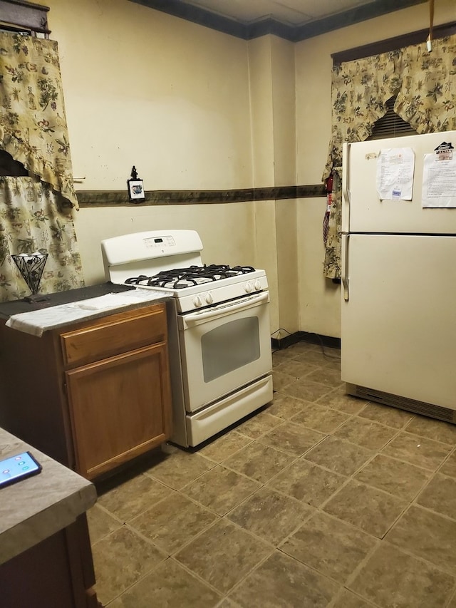 kitchen with crown molding and white appliances