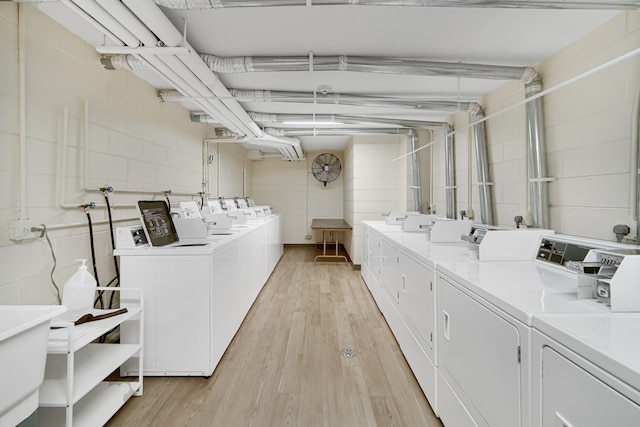 laundry room featuring washing machine and dryer and light wood-type flooring