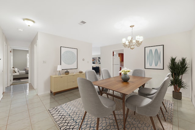 tiled dining space featuring a notable chandelier