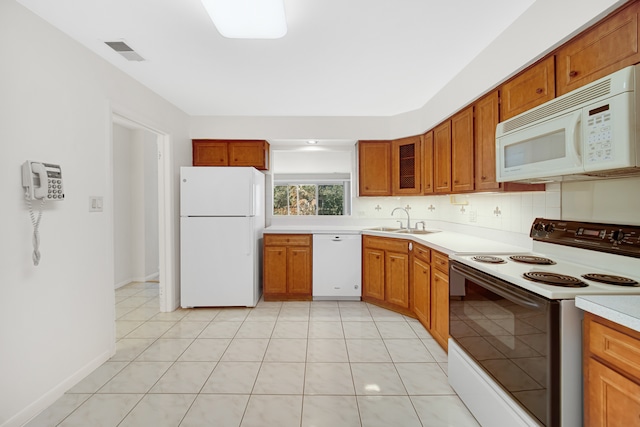 kitchen featuring white appliances, sink, light tile patterned floors, and backsplash