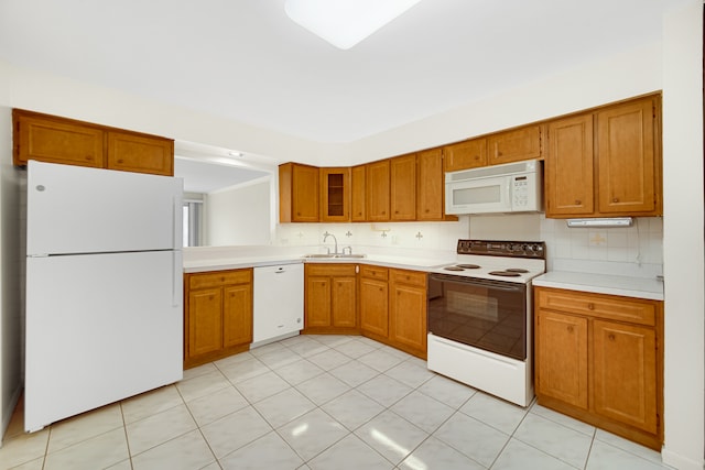 kitchen with light tile patterned flooring, sink, white appliances, and decorative backsplash