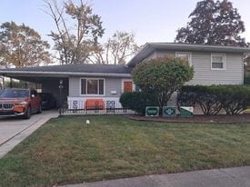 view of front of home with a carport and a front lawn