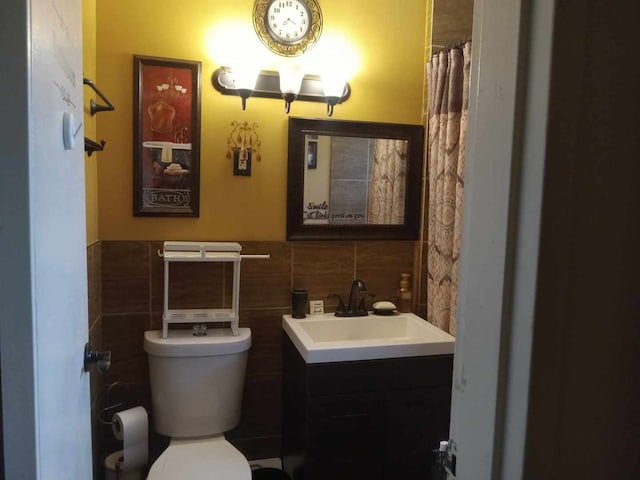 bathroom featuring tile walls, vanity, toilet, and a shower with shower curtain