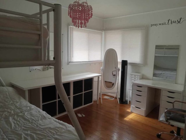 bedroom featuring wood-type flooring and an inviting chandelier