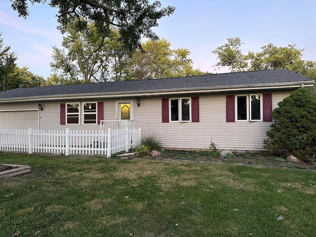 ranch-style house featuring a garage and a front lawn