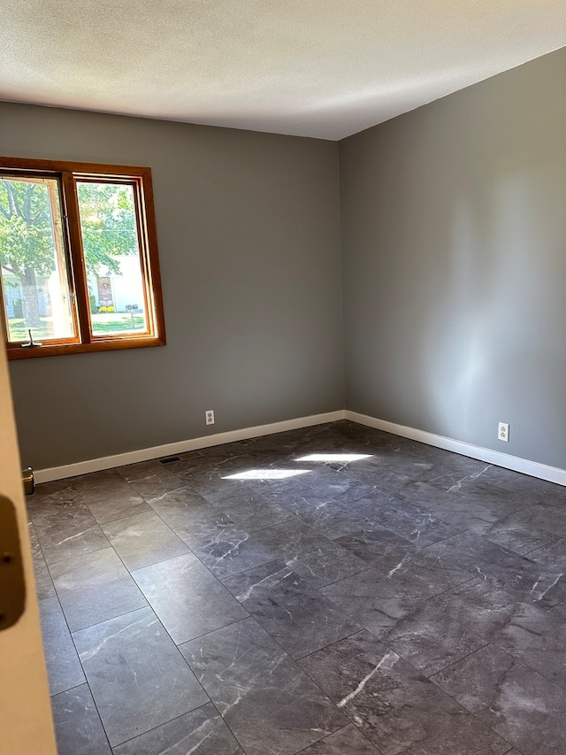 spare room with a textured ceiling