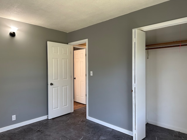 unfurnished bedroom with a closet and a textured ceiling