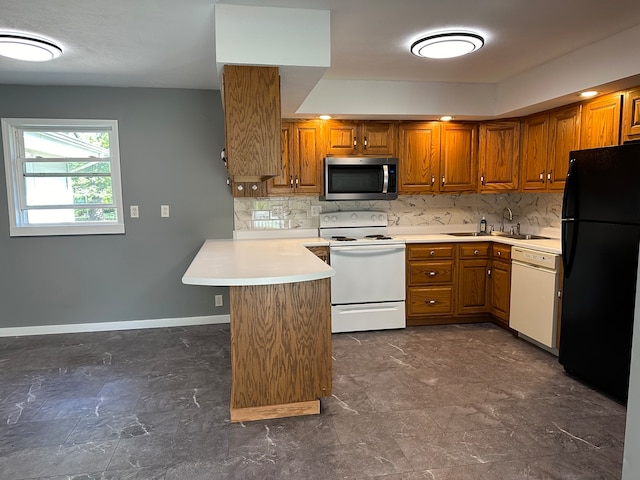 kitchen featuring kitchen peninsula, tasteful backsplash, sink, and white appliances