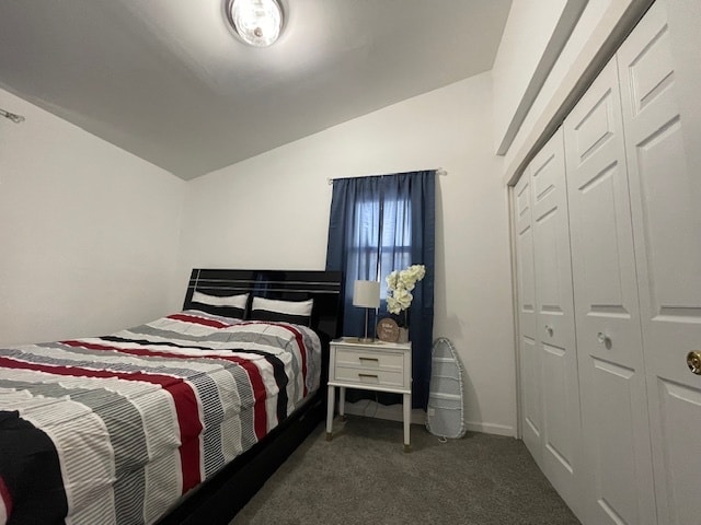 carpeted bedroom with a closet and lofted ceiling