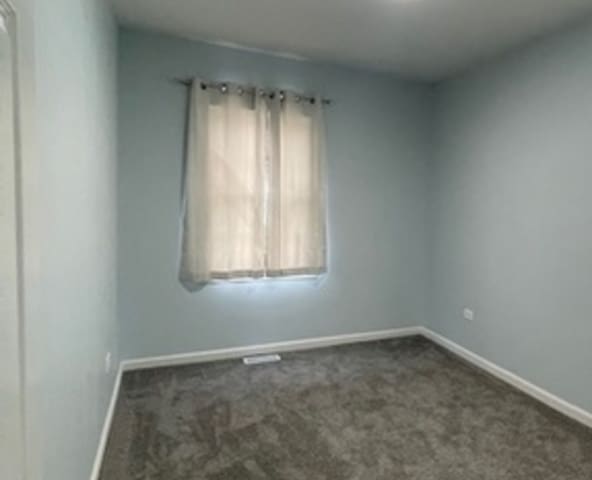 unfurnished room featuring dark carpet