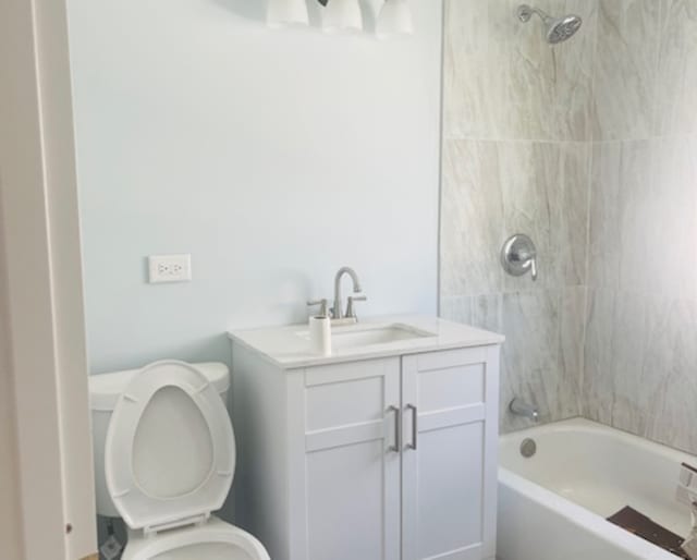 full bathroom with tiled shower / bath combo, vanity, and toilet