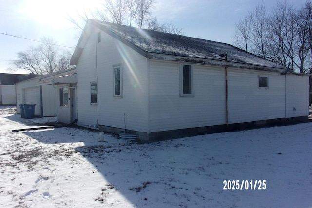 view of snow covered exterior with a garage