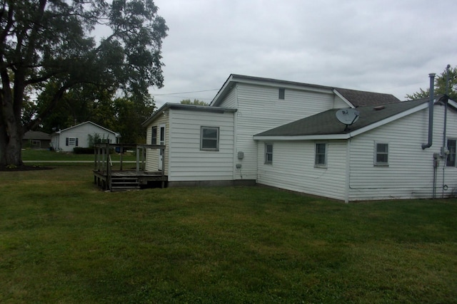 rear view of house with a wooden deck and a yard