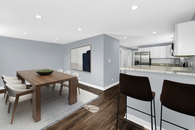 dining area featuring sink and dark hardwood / wood-style flooring