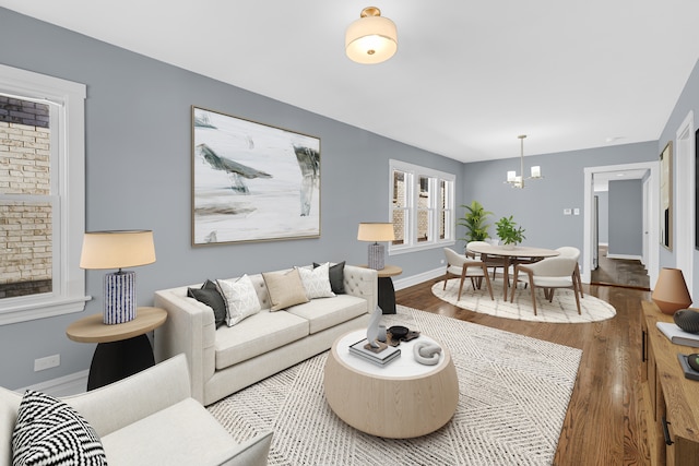 living room with a notable chandelier and dark wood-type flooring