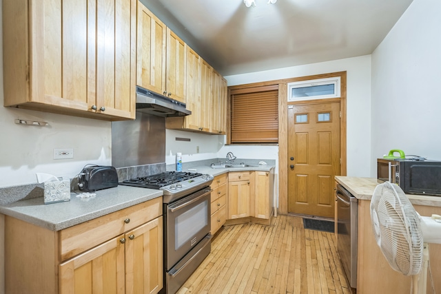 kitchen featuring appliances with stainless steel finishes, light brown cabinets, sink, and light hardwood / wood-style floors