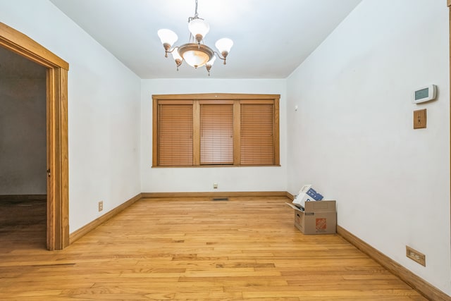 unfurnished dining area with light hardwood / wood-style flooring and a chandelier