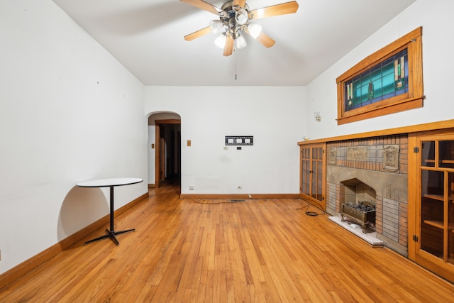 unfurnished living room with ceiling fan, light hardwood / wood-style flooring, and a fireplace