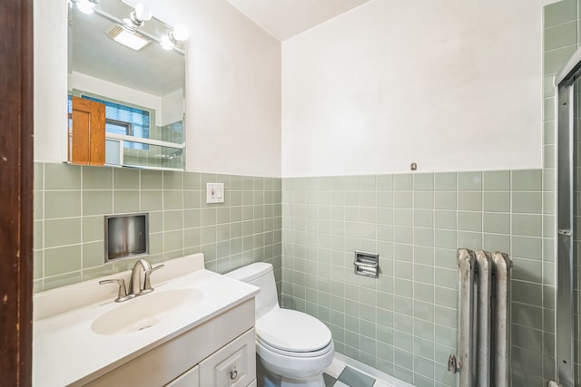 bathroom with vanity, toilet, tile walls, and an enclosed shower