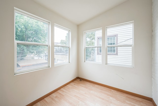 empty room featuring vaulted ceiling and light hardwood / wood-style floors