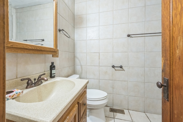 bathroom featuring vanity, toilet, tile walls, and tile patterned flooring