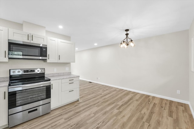 kitchen featuring light hardwood / wood-style flooring, stainless steel appliances, white cabinets, and an inviting chandelier