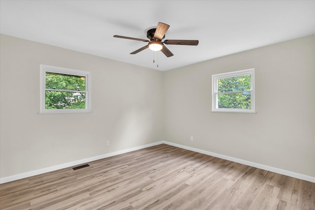 empty room with ceiling fan and light hardwood / wood-style floors