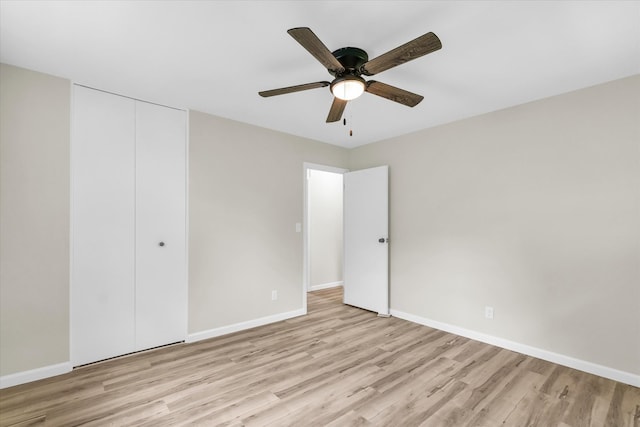 unfurnished bedroom featuring a closet, light hardwood / wood-style floors, and ceiling fan