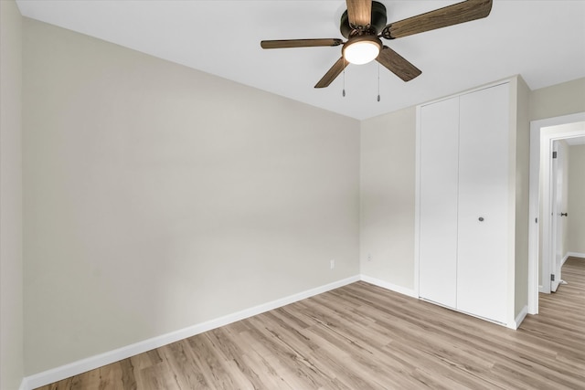 unfurnished bedroom with ceiling fan, light wood-type flooring, and a closet