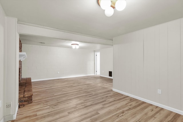 interior space with a fireplace, light hardwood / wood-style flooring, and brick wall