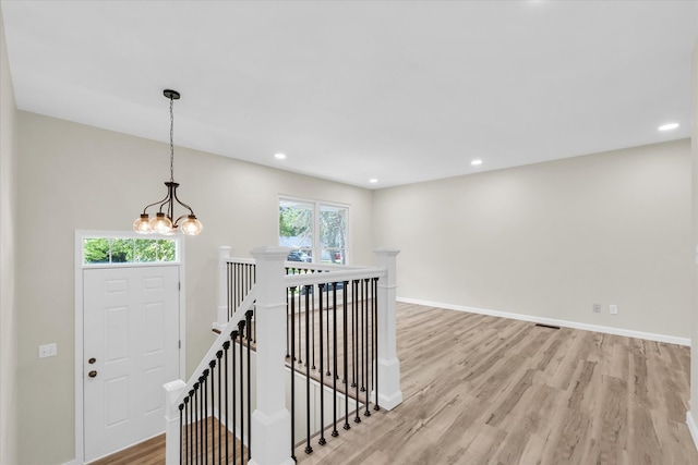 interior space with light wood-type flooring, a chandelier, and a healthy amount of sunlight