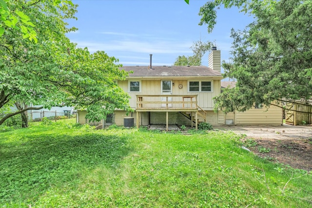 rear view of house with a lawn, central AC, a wooden deck, and a patio area