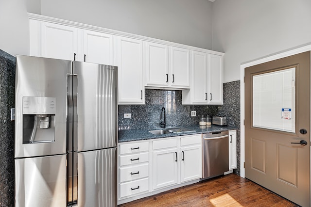 kitchen with stainless steel appliances, dark hardwood / wood-style flooring, and white cabinetry