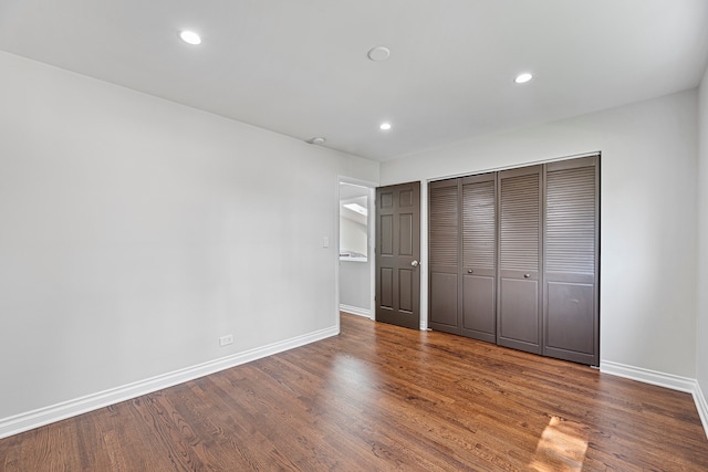 unfurnished bedroom with a closet and dark hardwood / wood-style floors