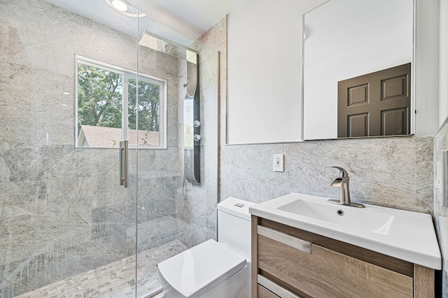 bathroom with tile walls, vanity, toilet, and a shower with door