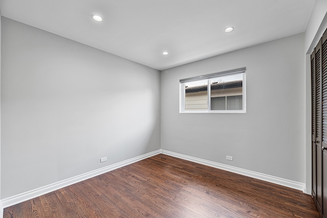 unfurnished bedroom with a closet and dark hardwood / wood-style flooring