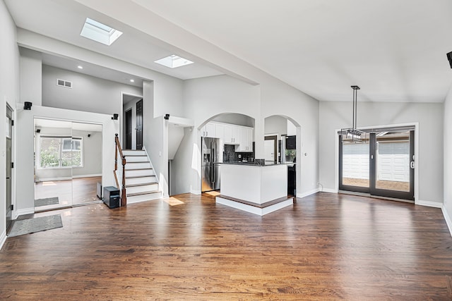 unfurnished living room with a towering ceiling, dark wood-type flooring, and french doors