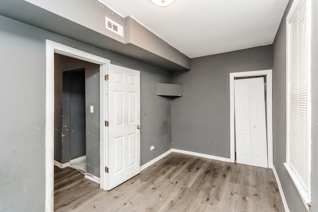 unfurnished bedroom featuring light hardwood / wood-style flooring and a closet