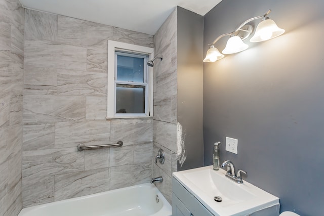 bathroom featuring tiled shower / bath combo and vanity