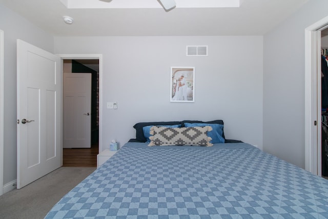 carpeted bedroom with ceiling fan and a skylight