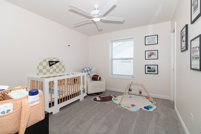 carpeted bedroom featuring a crib and ceiling fan