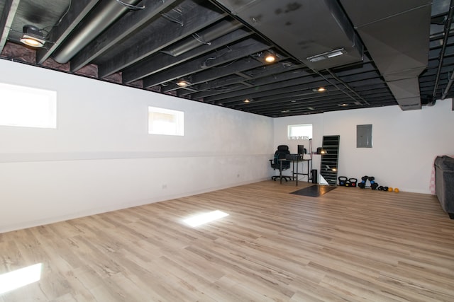 exercise room featuring light hardwood / wood-style flooring and electric panel