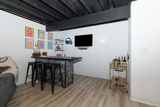 bar featuring hardwood / wood-style floors and beamed ceiling