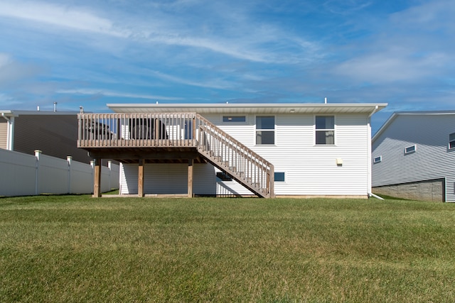 back of property featuring a wooden deck and a yard