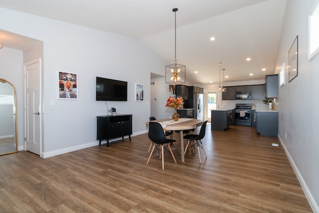 dining space featuring lofted ceiling and dark hardwood / wood-style floors