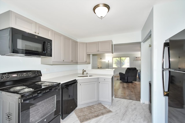 kitchen featuring sink, kitchen peninsula, gray cabinetry, black appliances, and light hardwood / wood-style floors