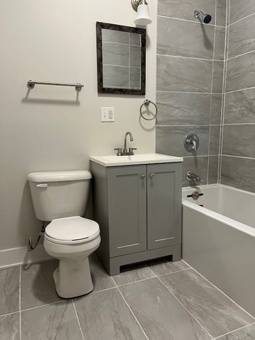 full bathroom featuring tiled shower / bath combo, vanity, and toilet