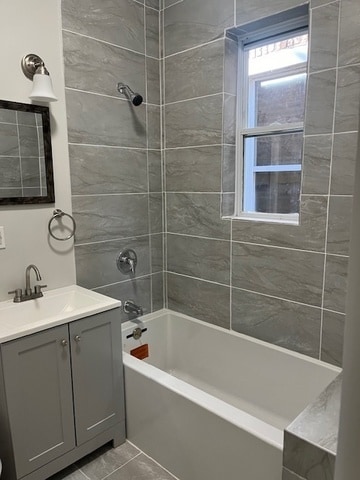 bathroom featuring vanity, tiled shower / bath combo, and tile patterned flooring