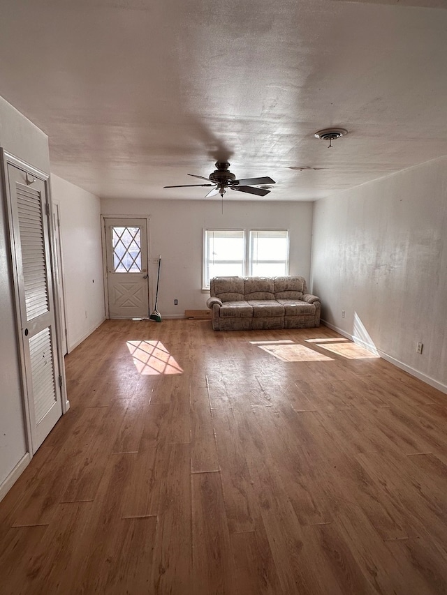 unfurnished living room with hardwood / wood-style flooring and ceiling fan